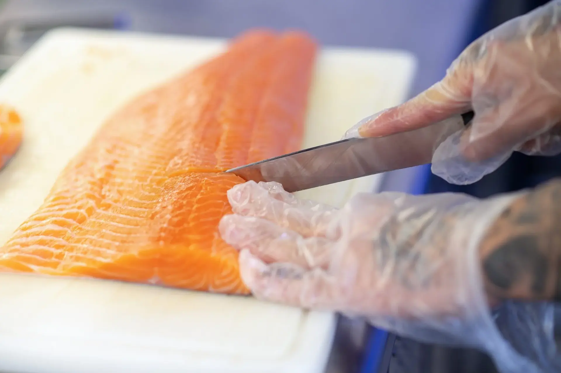 Man's hands cutting a fish on a cutting board