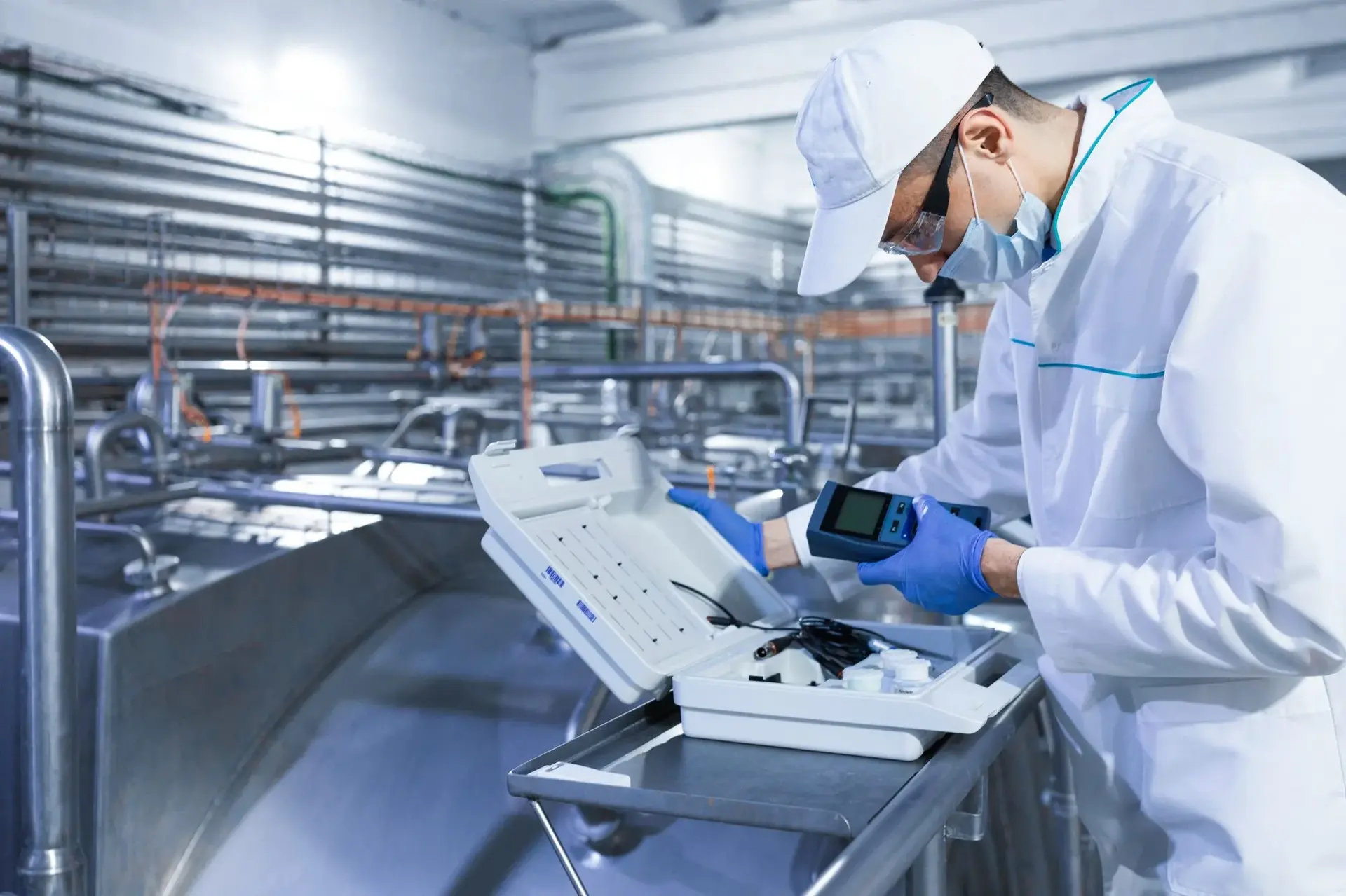 Technologist adjusting a device in a food factory department