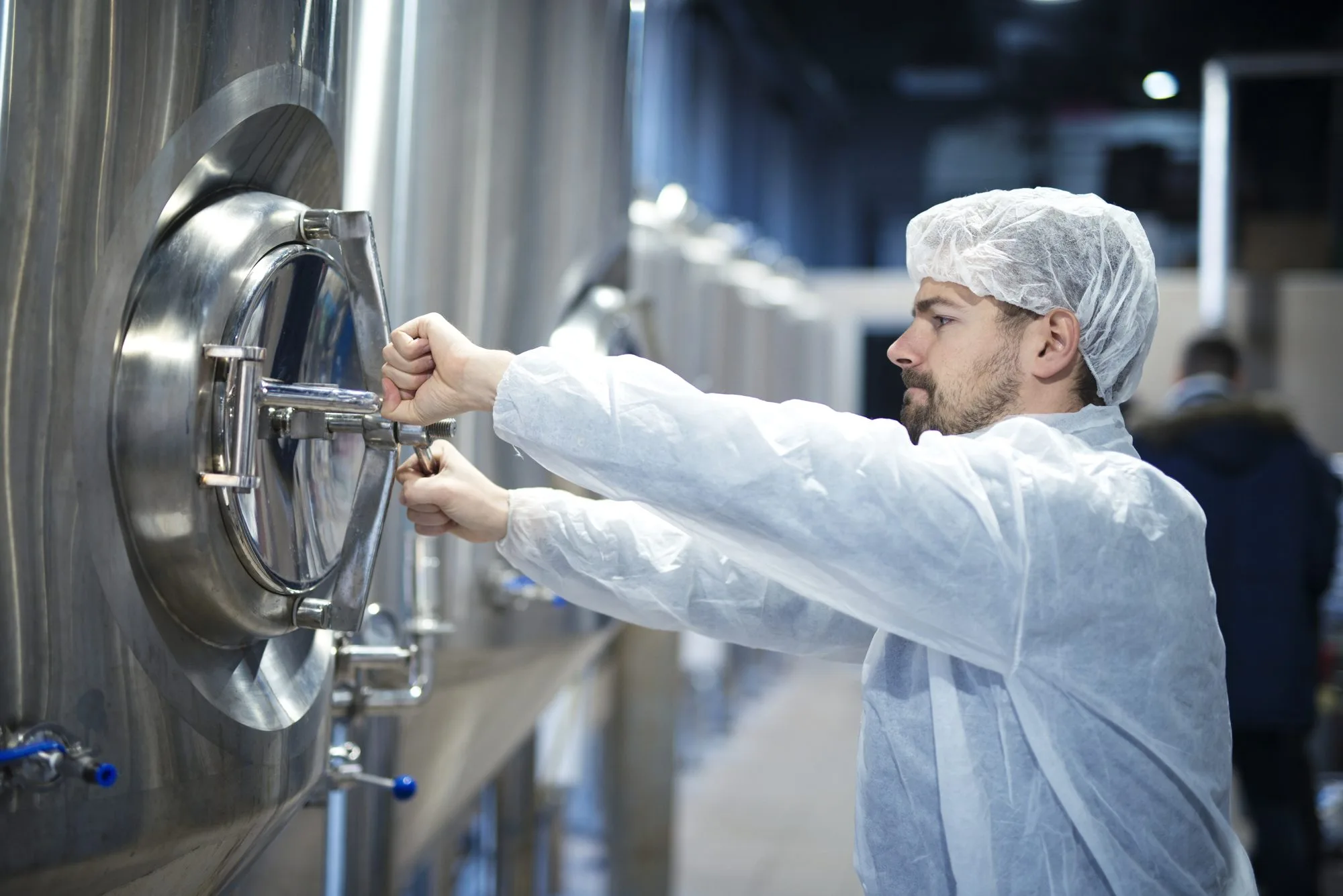 Industry worker opening the hatch of an industrial machine